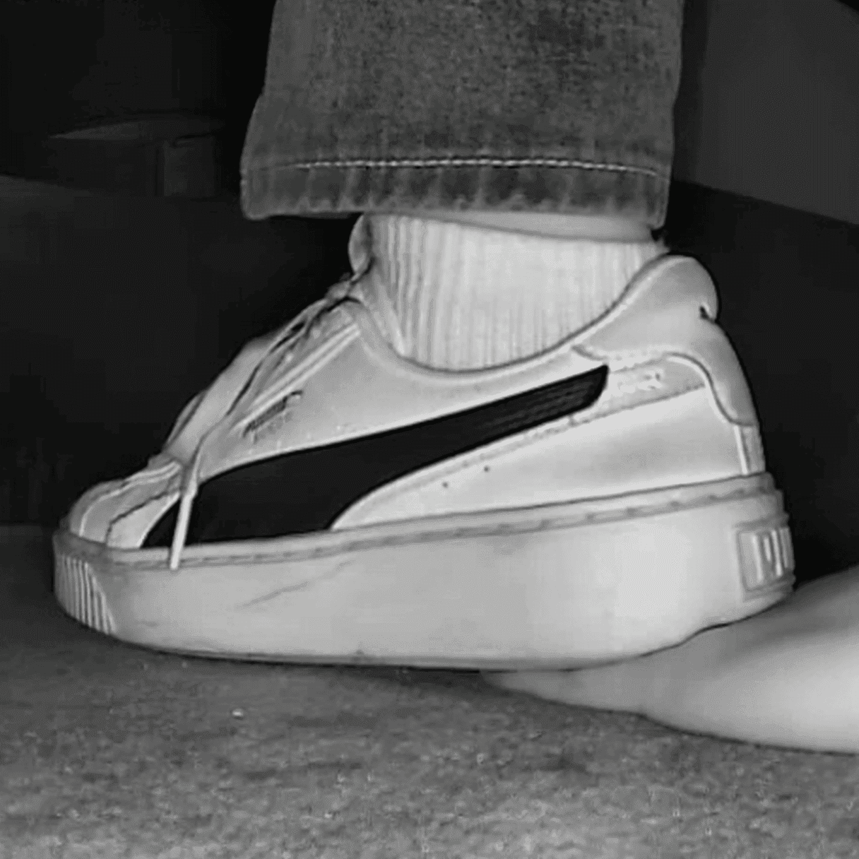 Woman candid hand trample with white socks and Puma sneakers in cinema thumb 2