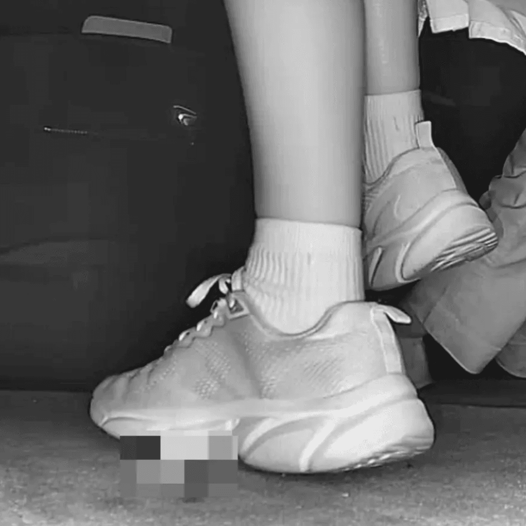 Woman in sneakers and white socks candid crushing in movie theater